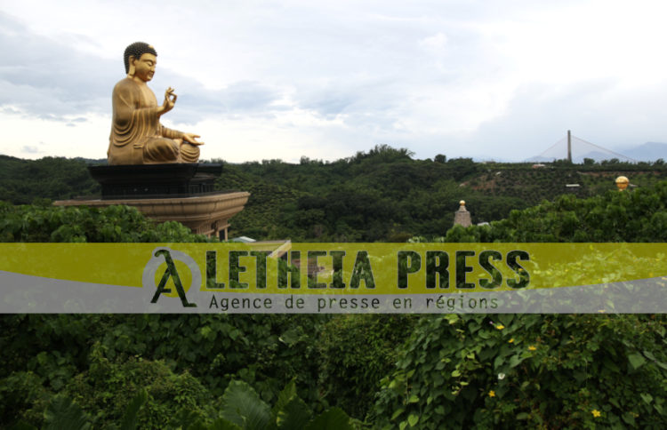 Un Bouda monumental émerge au dessus d'une forêt d'arbres à litchis. (Aletheia Press / M.Railane)